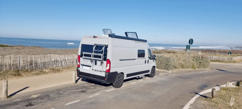 Fourgon aménagé gris en bord de mer